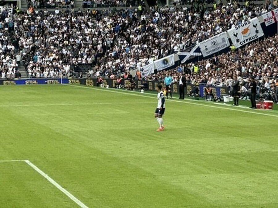 토트넘 선수 워밍업 — 팬들이 깃발로 응원 준비 중인 모습